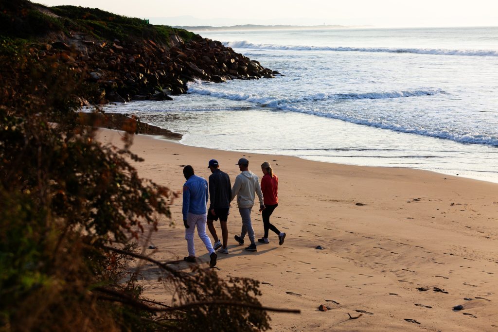 A group reflecting quietly near the ocean, symbolising clarity and support from an addiction recovery center.